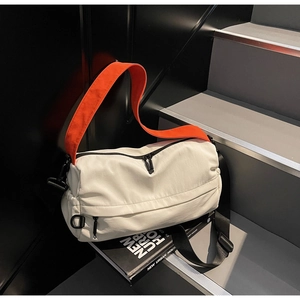 Detail of white nylon messenger bag with orange crossbody strap and double zippers