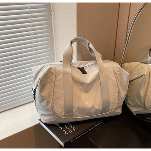 Détail du sac de sport gris avec logo NOCO et texture en tissu nylon résistant