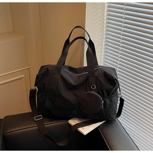 Detail einer großen schwarzen Fitness-Reisetasche mit Schultergurt und Netztasche