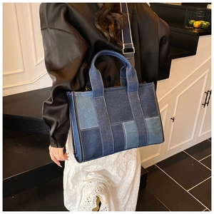 Back view of a large patchwork denim tote bag with adjustable shoulder strap on model