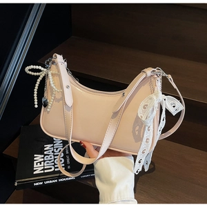 Dettaglio borsa rosa con elegante fiocco di perle e finiture in pizzo bianco
