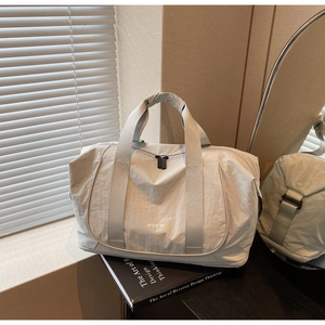 Détail du sac de sport en nylon gris clair montrant les poignées et la fermeture éclair