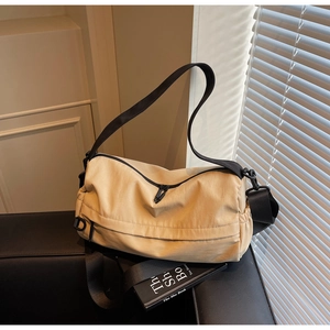 Detail of apricot large capacity crossbody bag with adjustable wide strap and nylon fabric