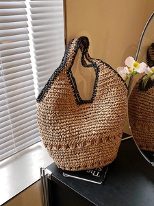 Handwoven straw tote bag with black contrast piping and stylish wavy edge design