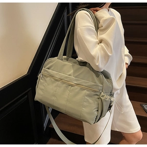 Detailed close-up of large mint green quilted travel bag with spacious pockets and straps