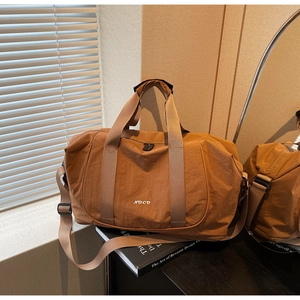 Détail du grand sac de yoga en nylon marron avec logo NO CO et bandoulière réglable
