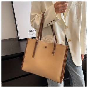 Detail of a contrast color large tote bag with buckle straps and metal D-ring hardware