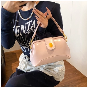 Vue détaillée du sac carré rose avec boucle jaune et crochet en métal doré sur modèle
