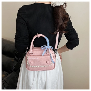 Pink retro Boston bag featuring lace edges and blue checkered bow worn by a model