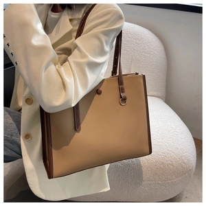 Detail of a khaki tote bag showing fine stitching and high-quality leather texture