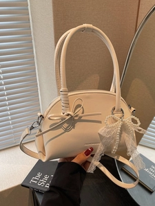 Elegante borsa a mano beige con fiocco, ciondolo in pizzo perlato e tracolla