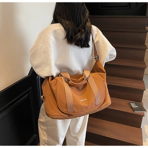 Détail de la bandoulière marron réglable et de la couche d'extension de ce sac de fitness camel
