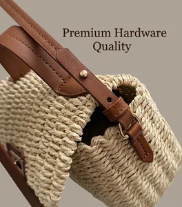 Detail of woven straw handbag with premium gold hardware and brown leather strap