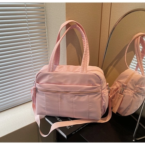 Detail of pink quilted travel tote with front zipper pocket and adjustable shoulder strap