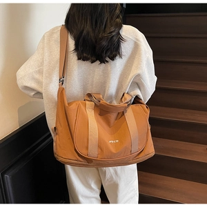 Détail du sac de sport yoga en nylon caramel avec bandoulière large et logo blanc