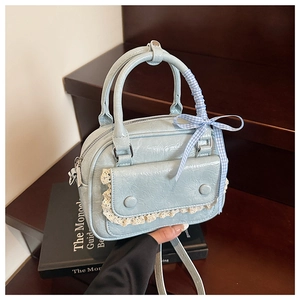 Close-up of light blue mini handbag with pleated PU texture, lace trim and bow handle