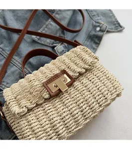 Close-up of woven straw bag featuring premium brown leather strap and gold metal lock