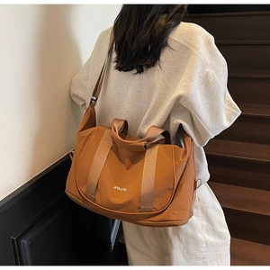 Détail de la bandoulière réglable et du logo NOCO sur ce sac de yoga et fitness orange