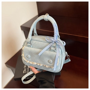 Detail of light blue PU leather bag with lace trim flap, pleats and checkered bow ribbon
