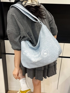 Sac hobo en toile bleu clair avec motif chien et texte Sunshine Nika porté à l'épaule
