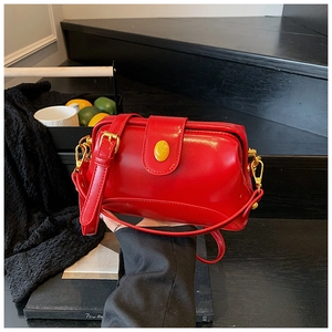 Détail du sac docteur rouge avec finitions dorées et perle décorative jaune sur le fermoir