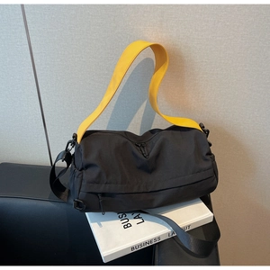 Detail of waterproof black nylon bag with yellow straps and functional side pockets