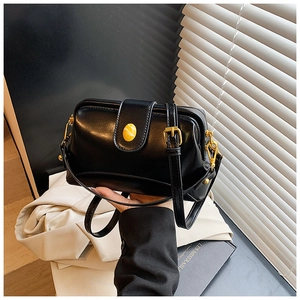 Détail du sac Boston noir vintage avec cadre en métal doré et fermoir aspect marbre