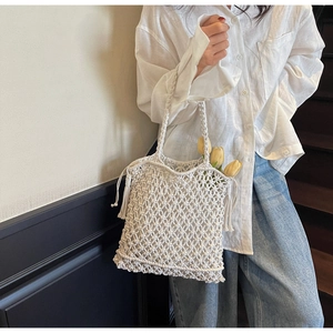 Vue détaillée du sac cabas blanc crocheté à la main avec glands et motifs en maille