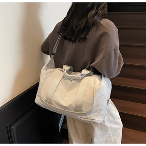 Détail du sac de sport multifonctionnel blanc cassé avec poignées et logo de marque