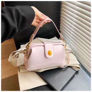Détail du sac docteur en cuir rose avec boucle jaune et bandoulière réglable