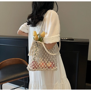 Détail du sac de plage en macramé blanc fait main avec de longues franges et fleurs
