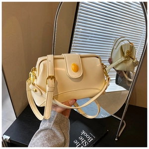 Détail de ce sac vintage crème avec une pierre ambrée et des finitions métalliques dorées