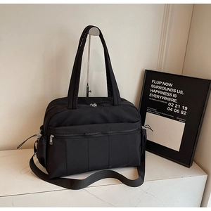Detail of multi-pocket black waterproof travel bag with adjustable strap and handles