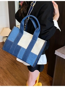 Large colorblock denim tote bag with adjustable strap shown in a lifestyle indoor setting