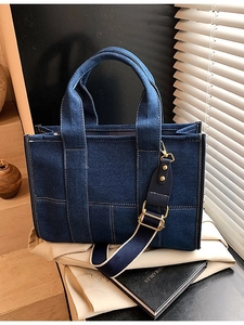 Deep blue denim tote bag with contrast stitching and adjustable wide shoulder strap