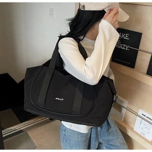 Gros plan du sac de yoga en nylon noir avec grande capacité et logo NOCO détaillé