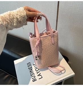 Dettaglio della mini borsa tote rosa con texture a coccodrillo e ciondolo a cuore argento