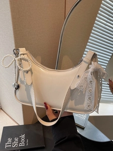 Borsa hobo bianca a mezza luna con catena di perle e pizzo in un ambiente minimalista