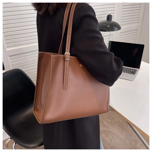 Brown leather tote bag with white contrast stitching and adjustable strap details