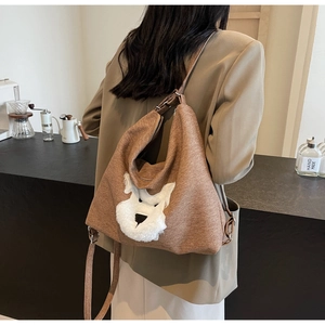 Detail of a brown textured canvas tote with a cute plush dog applique for daily commuting