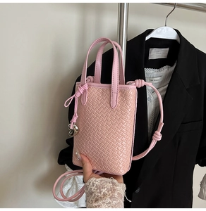 Borsa tote rosa intrecciata con ciondolo a cuore in argento lucido e tracolla annodata