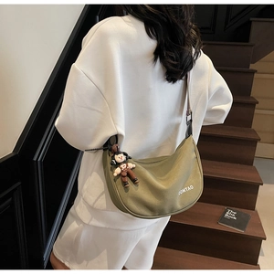 Olive green crescent canvas bag with woven strap and logo shown on model