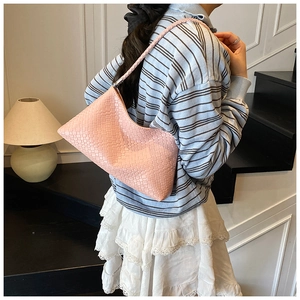 Détail du sac hobo tissé rose avec texture en damier et fine bandoulière tressée
