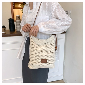 Vue détaillée du sac cabas en crochet tissé main avec bandoulière en cuir marron et logo