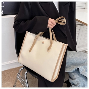 Detail of minimalist beige and brown tote bag with buckle straps for office commuting