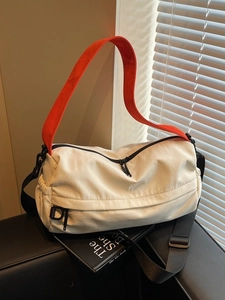 Fashionable ivory nylon Boston bag with vibrant orange crossbody strap for women
