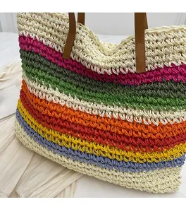 Close-up of rainbow woven straw tote bag featuring colorful stripes and leather straps