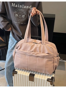 Large capacity travel bag in dusty rose nylon featuring multi-layer storage pockets