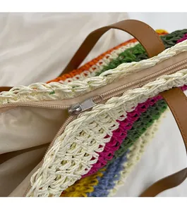 Close-up of a smooth silver metal zipper and woven texture on a rainbow crochet tote bag