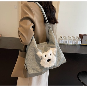 Detail of grey tote bag featuring a cute 3D plush dog face on textured fabric